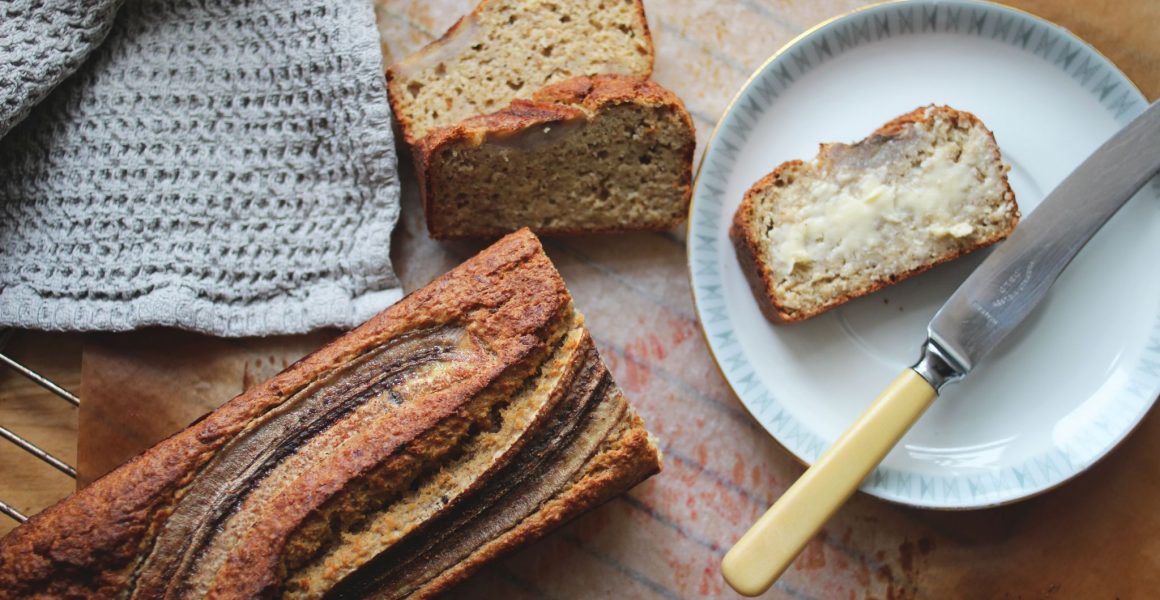 nystekt bananbrød på fjøl, kniv og smør